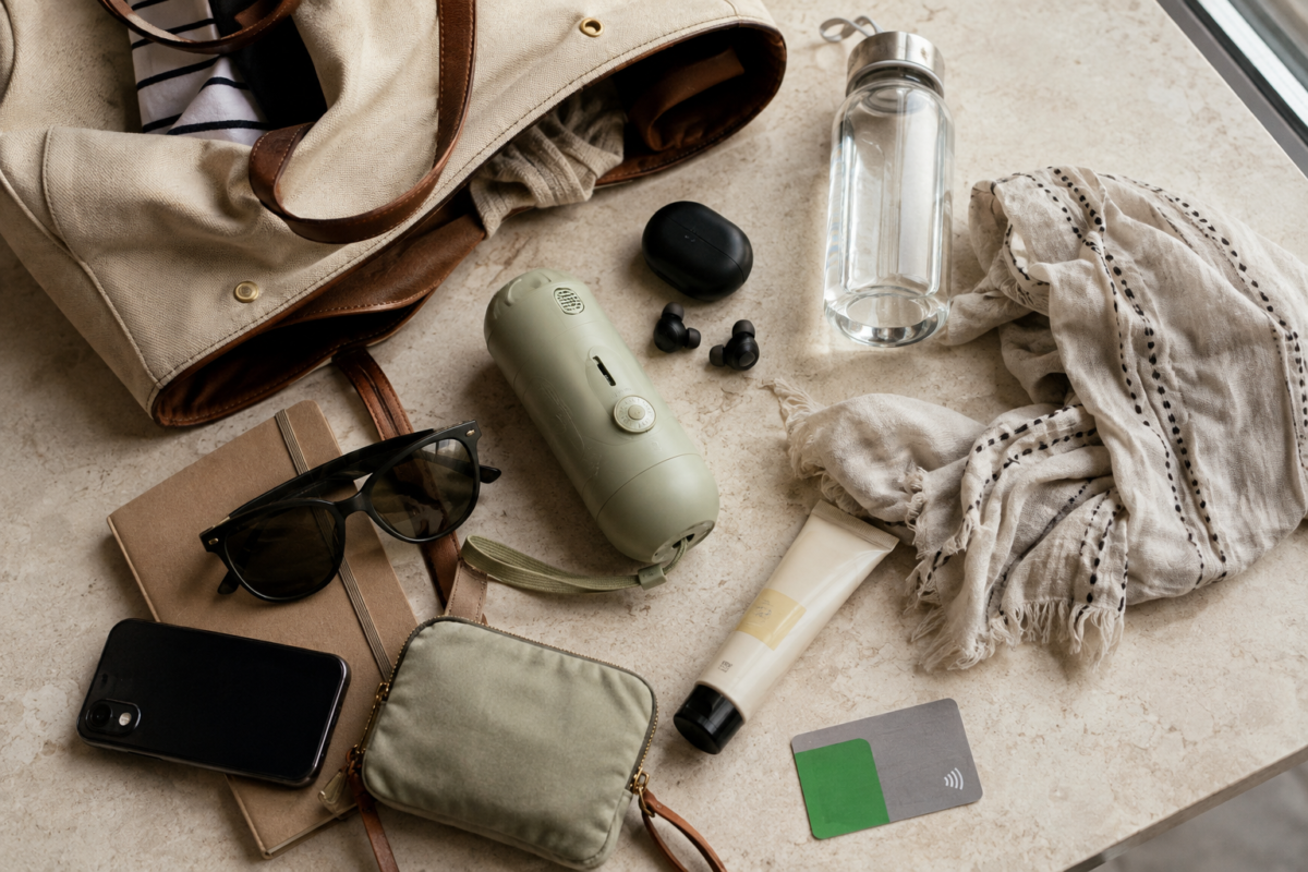 A portable cooling fan arranged with everyday essentials in a modern summer travel kit